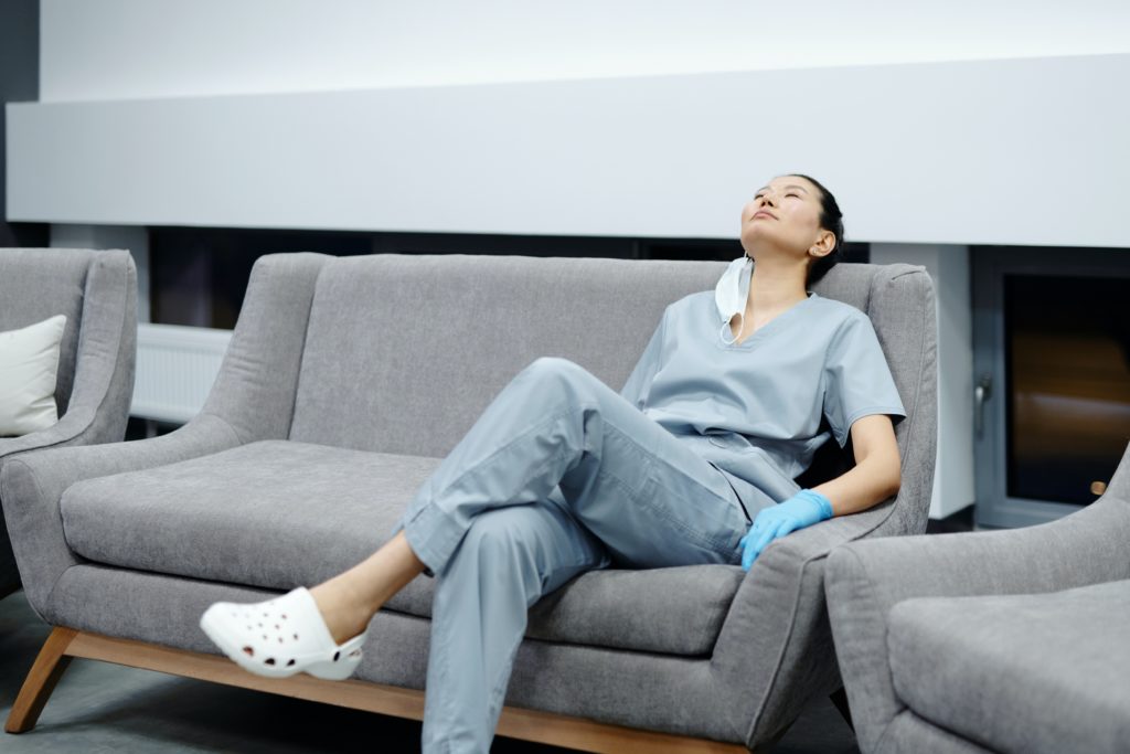 Healthcare worker sitting on couch - 