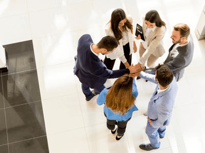 group of employees in a huddle with boosted employee morale